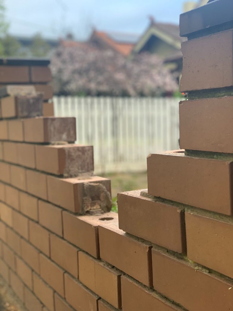 Image shows a brick fence needing brick repairs in Ballarat